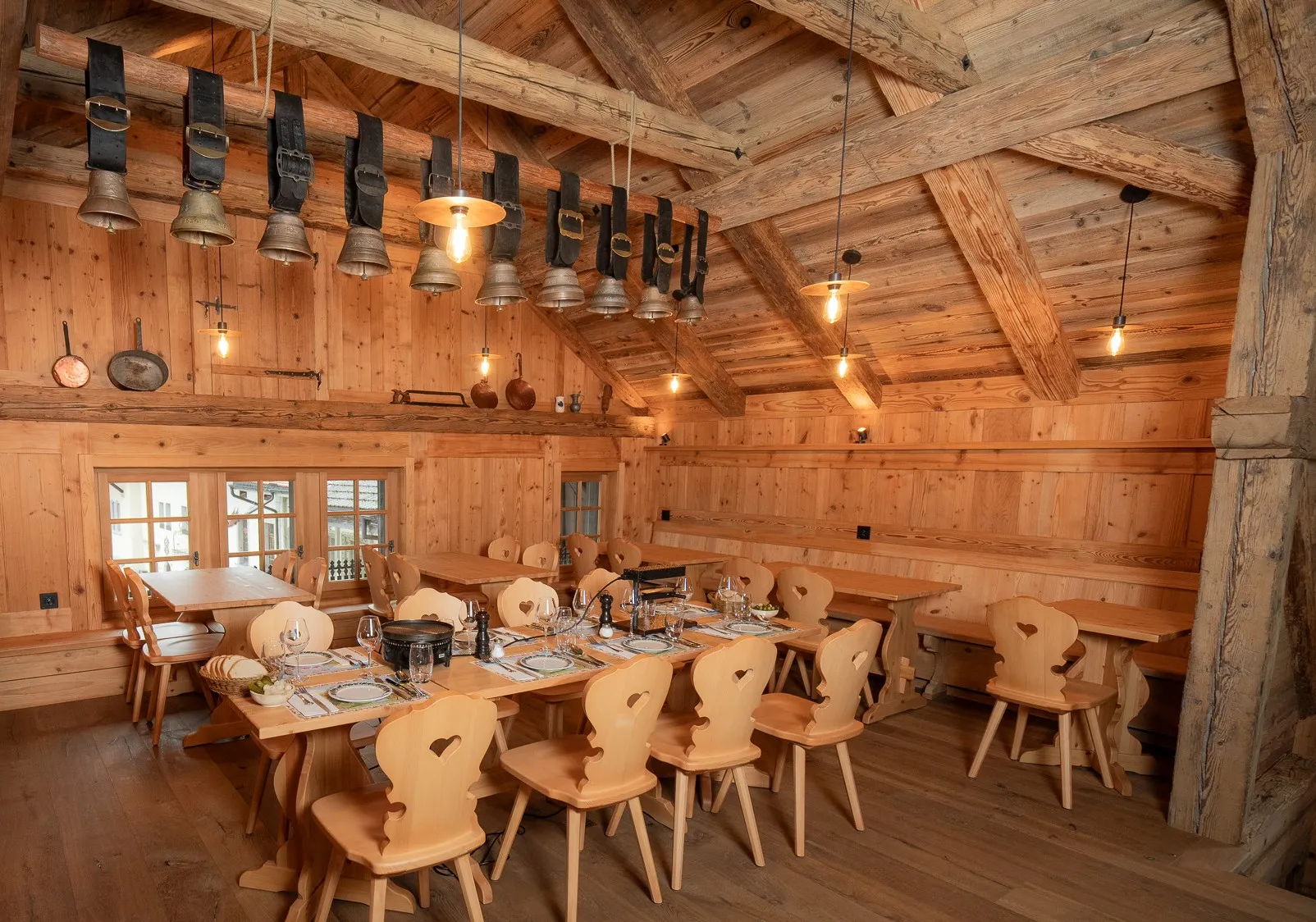 La grande salle boisée du Chalet, longue table dressée sous les poutres